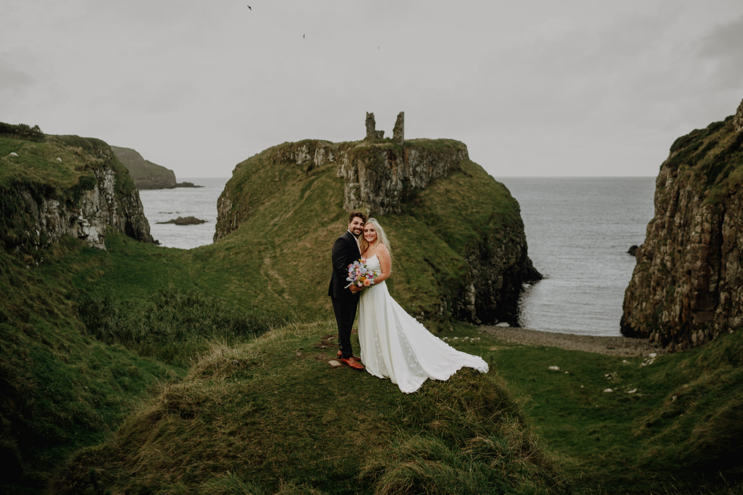Dunserverick Castle elopement in front of castle ruin at sunset in Northern Ireland